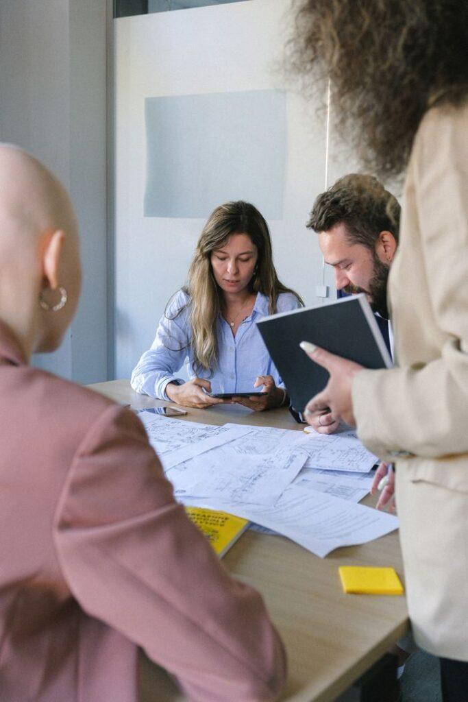 pexels-photo-5324957-5324957 Young colleagues using tablet and talking at table with important documents in business office