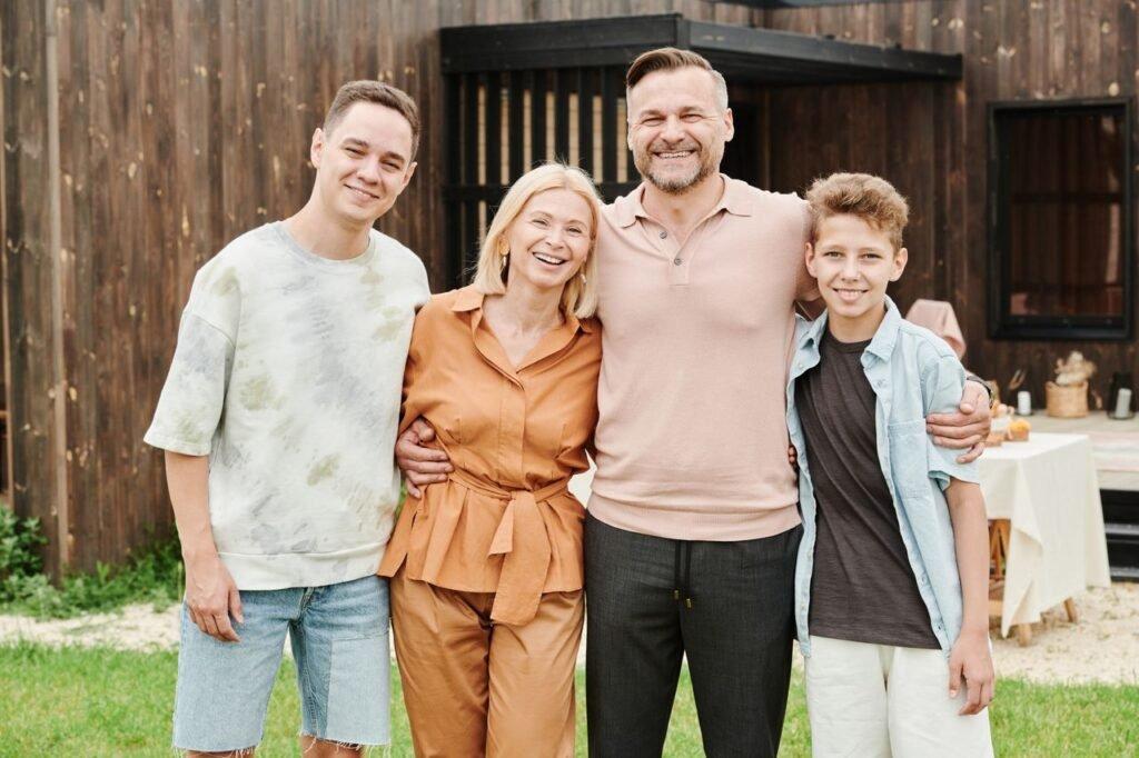 pexels-photo-8841115-8841115 Smiling family of four posing outdoors, capturing love and togetherness.